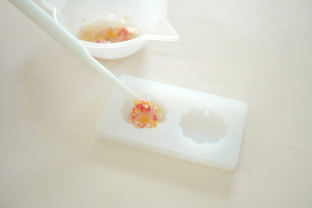 シリコンモールドにお花を混ぜたレジン液を注入する様子