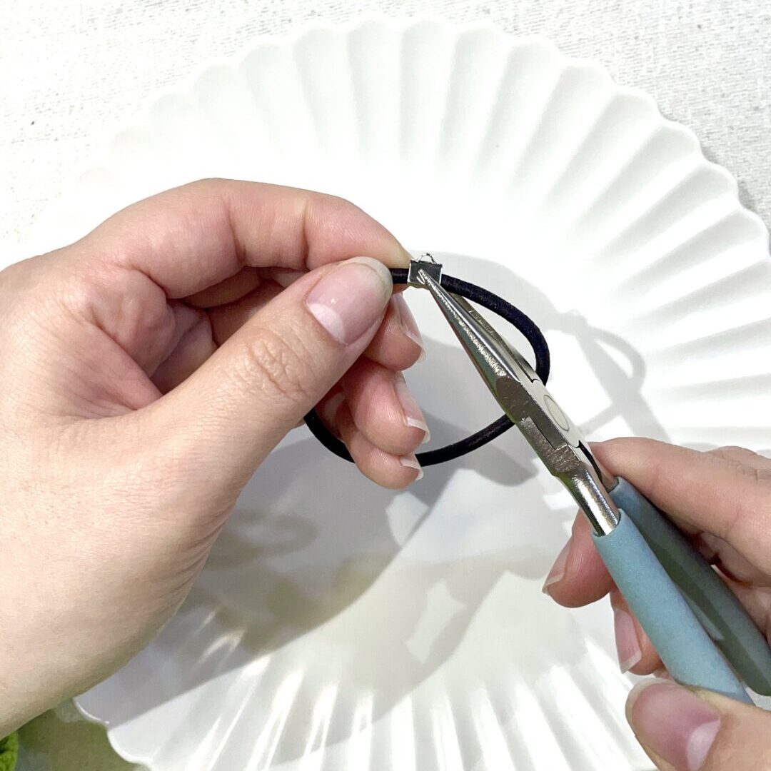 ヤットコを使用して金具を閉じている様子