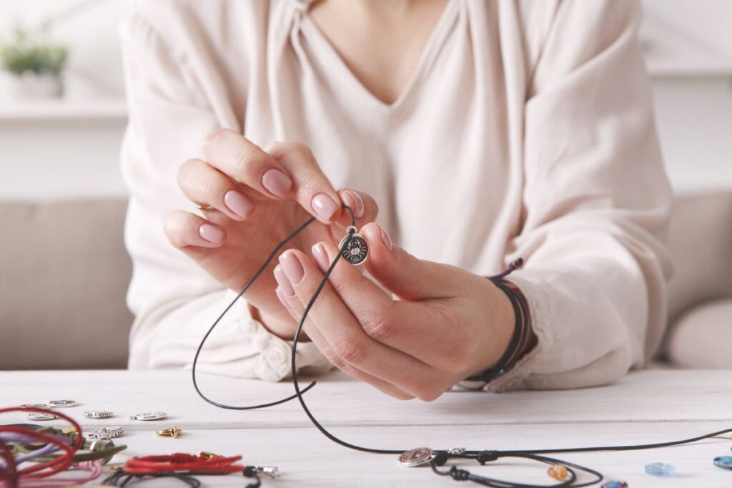 ハンドメイドAIを活用し制作したネックレスを見せる女性